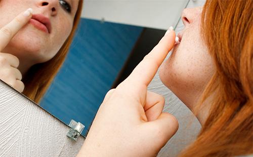 La mujer mancha los labios con crema