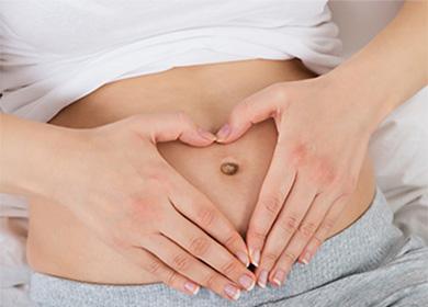 Cœur composé de doigts sur le ventre