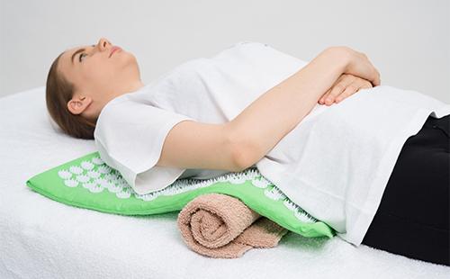 Une femme se couche sur l'applicateur Kuznetsova