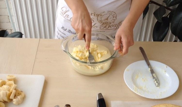 Комбинирайте маслото с кондензирано мляко и разбъркайте.