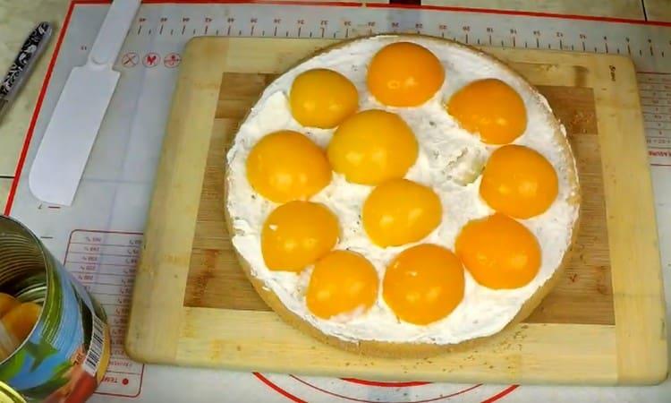 Întindem piersici din conserve deasupra cremei.