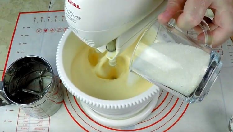 Adăugați zahărul în masa ouălor și bateți împreună.