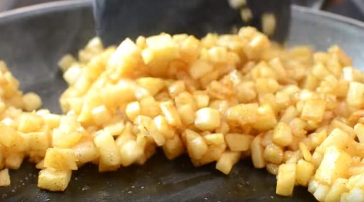 Prăjiți umplutura într-o tigaie cu unt pentru a carameliza merele.