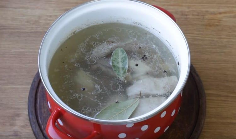 Към бульона добавете свински ребра, както и черен пипер и дафинов лист.