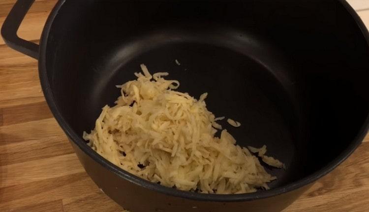 Riv potatis och lägg i en djup behållare för att laga mat köttfärs.