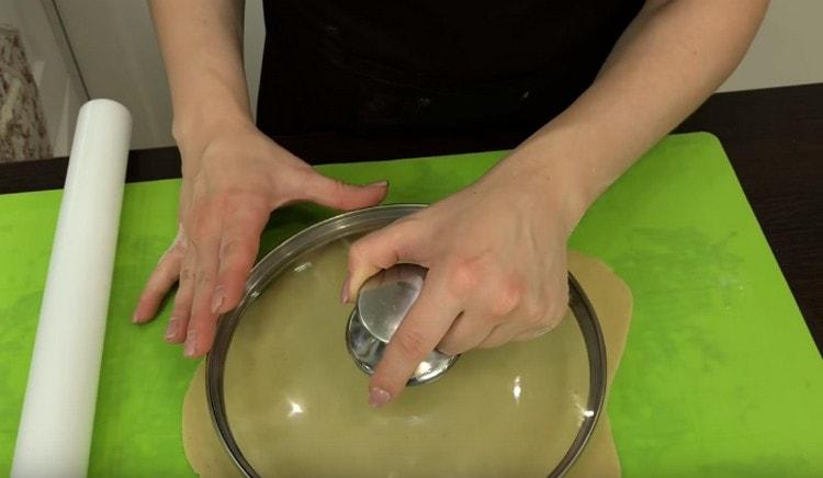 Cada peça é desenrolada com um rolo e uma tampa é cortada do bolo.