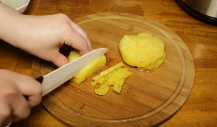 Ananas in Dosen würfeln.