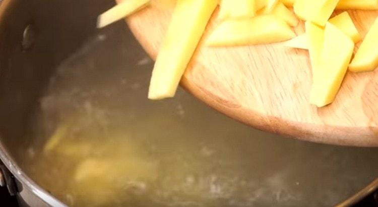 Wir geben gehackte Kartoffeln in die Brühe.
