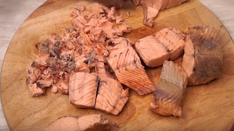 Den Fisch von den Samen trennen und in Stücke schneiden.