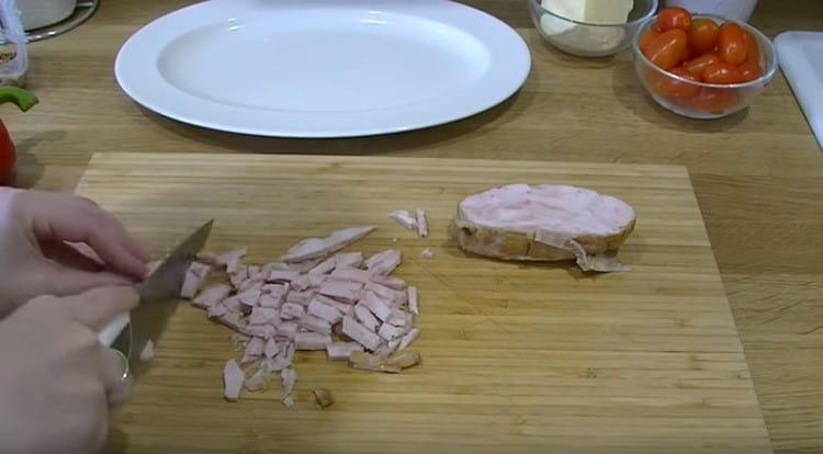 Tallar el pollastre fumat a trossos.