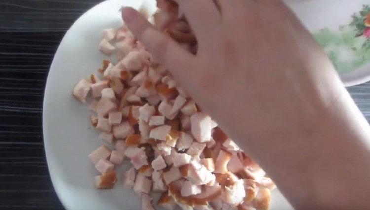 Разпределяме нарязаното пилешко месо с първия слой от ястието.