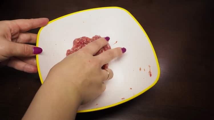 Bateti carnea tocata pentru a gati supa de chiftelute in aragazul lent