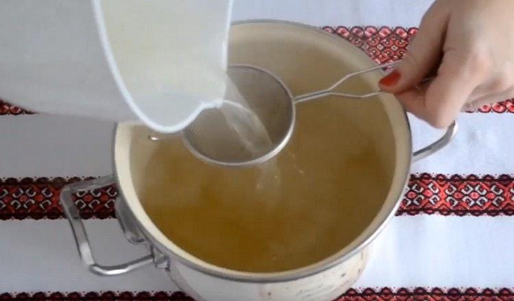 Hotový vývar se filtruje přes síto.