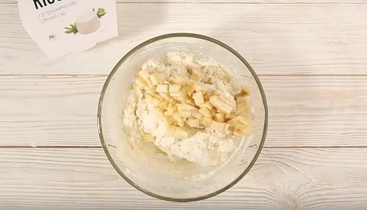 Adăugați banana tocată fin în aluatul de caș.