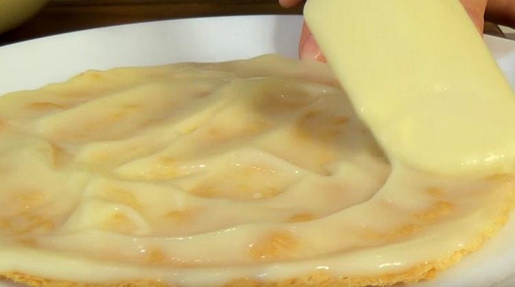 Intindem tortul, il ungem cu crema.