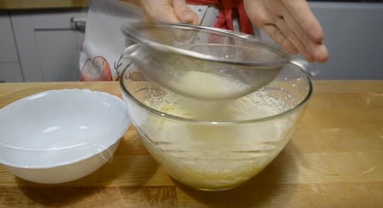 Tamisar la farina barrejada amb pols de cocció en aquesta massa.