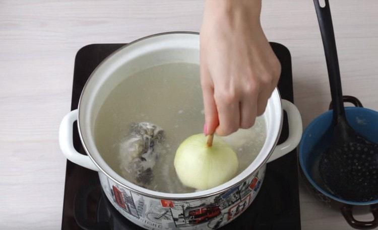 Wir geben eine ganze Zwiebel in die Brühe.