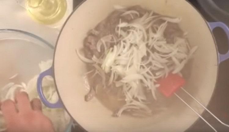 După câteva minute adăugați ceapa în carne.