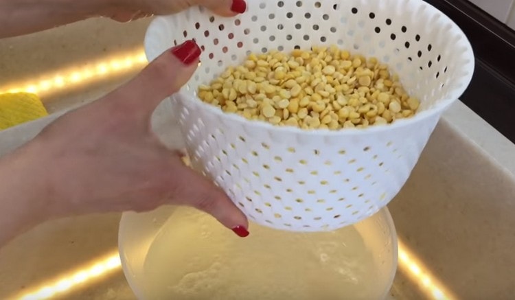 Scurgeți apa de mazăre și clătiți-o.