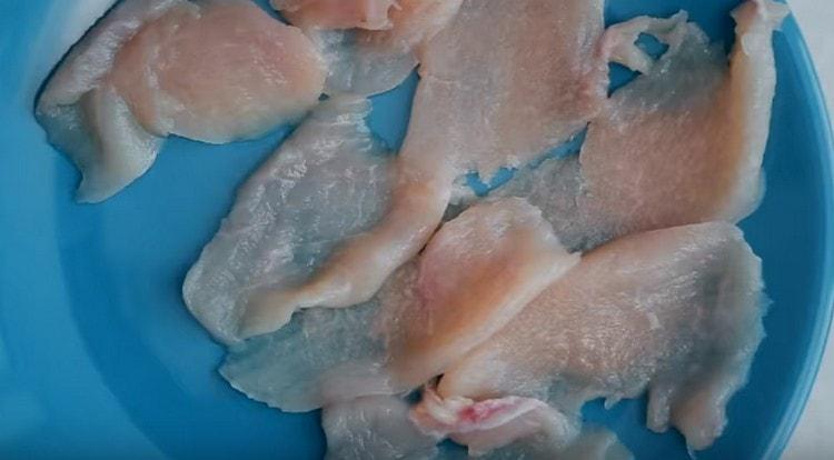 Gupitin ang fillet ng manok sa sobrang manipis na hiwa.