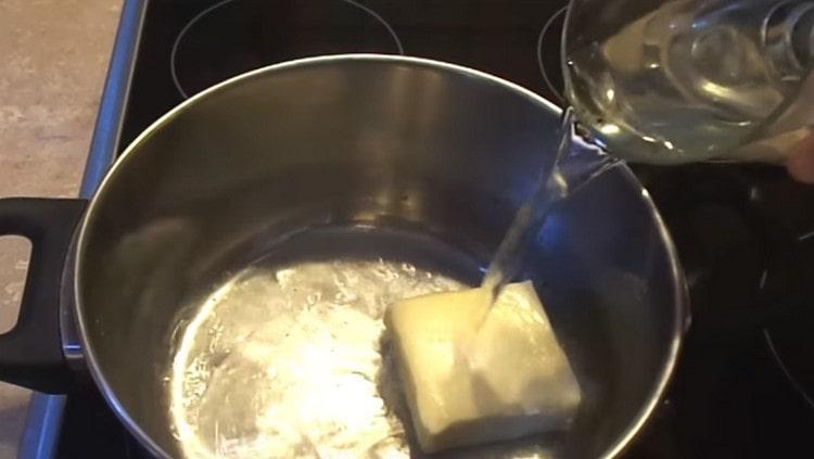 Colocamos uma panela no fogo, colocamos manteiga e adicionamos água.