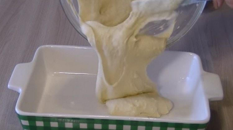 I bunden af ​​bageformen spreder vi det meste af dejen.