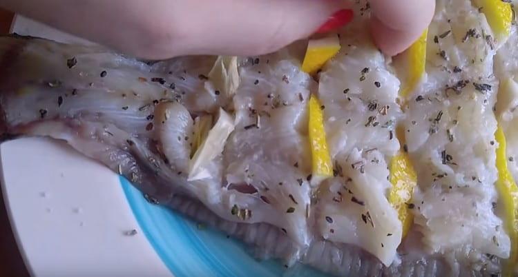 يتم إدخال الثوم المفروم جيدًا أيضًا بالقرب من شرائح الليمون.