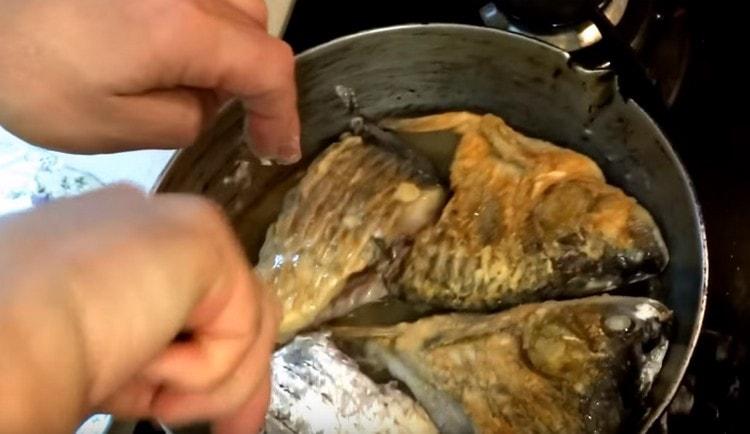 Terningstykker crucian karper i mel, steg dem i en gryde.