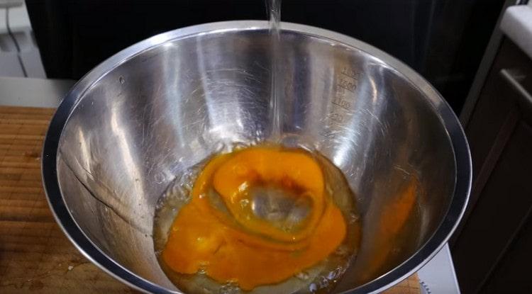 Zwei Eier in einer Schüssel ausschlagen.