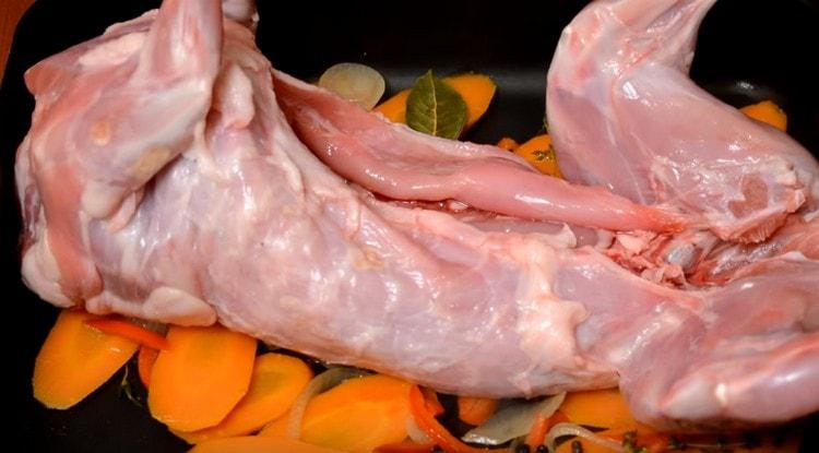 Punem legume preparate pe o foaie de copt și așezăm un iepure pe ele.