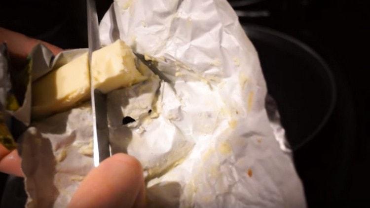 Schalten Sie den Slow Cooker ein und geben Sie ein Stück Butter in die Schüssel.