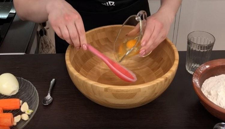 За теста комбинирайте водата с яйцето, разбъркайте.