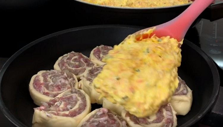 Разпределяме заготовките в отделен тиган, разпределяме соса отгоре.