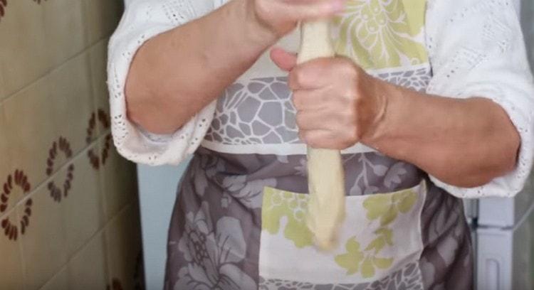 Нарежете парче тесто, оформете от него наденица.