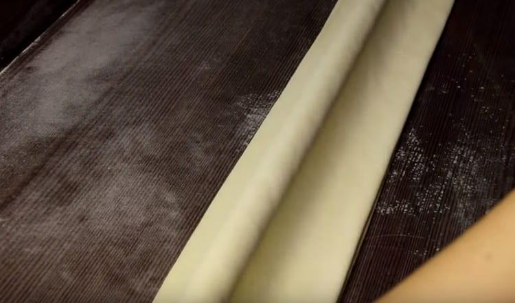 Ikinakabit namin ang kuwarta sa isang fairy tale at pagkatapos ay tiklupin ito sa maliit na layer.