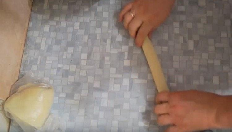 Нарежете парче от тестото и го навийте в наденица.