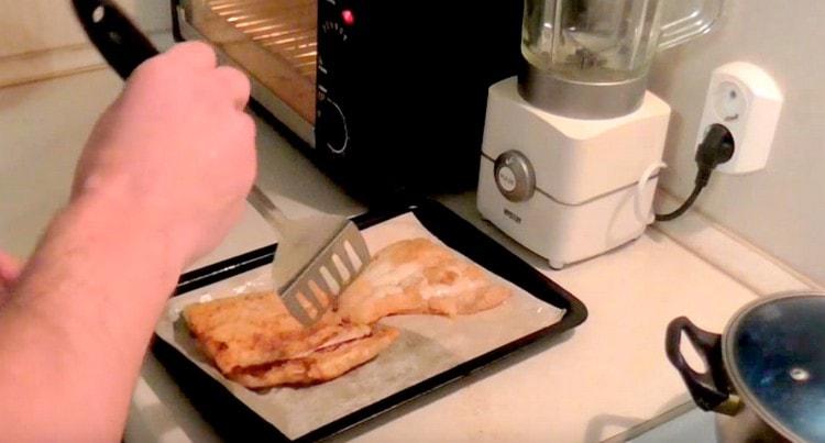 Ensuite, nous transférons le poisson sur une plaque à pâtisserie recouverte de parchemin.