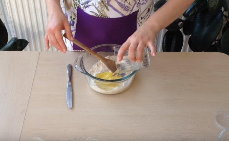 Afegiu dues clares d'ou als ingredients secs.