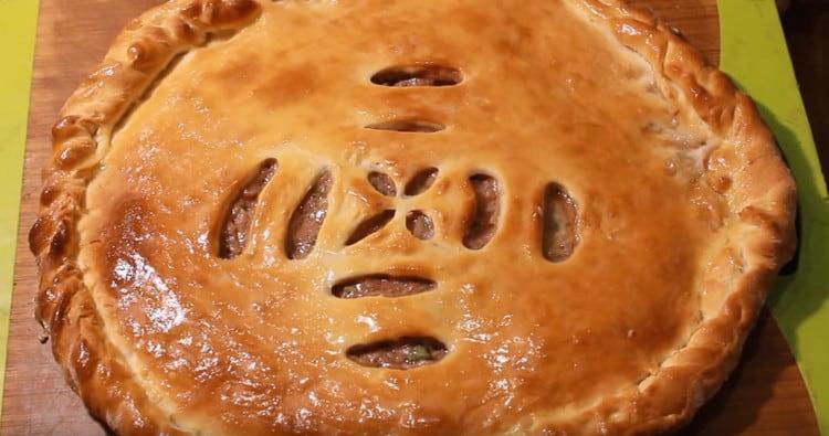 După coacere, plăcinta cu carne osetiană poate fi unsă cu o bucată de unt.