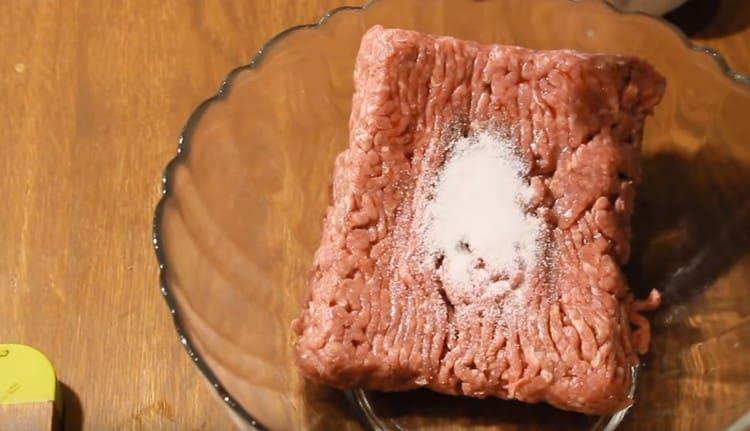 Adăugați sare și piper în carnea tocată.