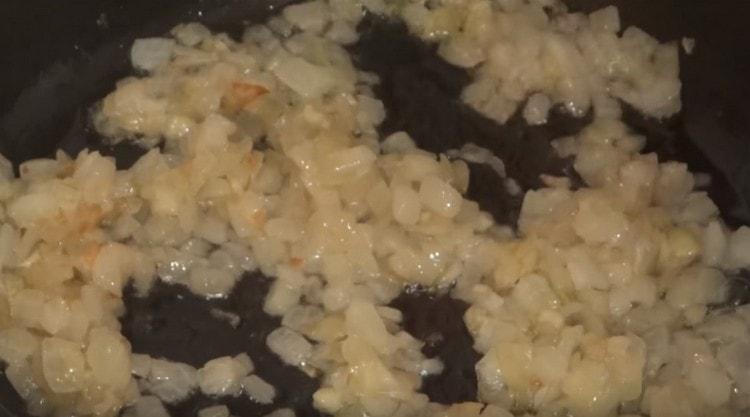 Prăjiți ceapa într-o tigaie cu ulei vegetal până se rumenesc.