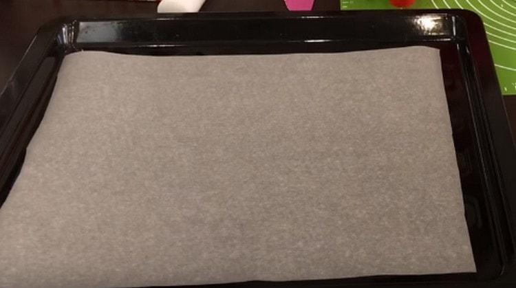 Pečicí list přikryjeme pekařským papírem.