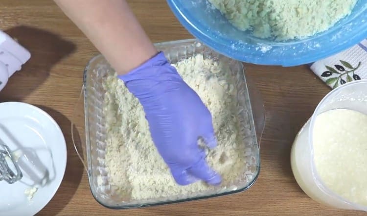 Distribuiamo la maggior parte delle briciole in modo uniforme lungo il fondo dello stampo, creando piccoli lati.