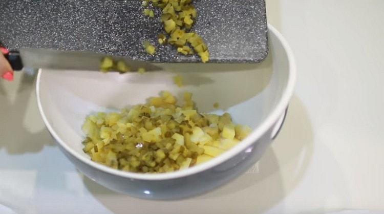 Agregue pepinos picados a las papas.