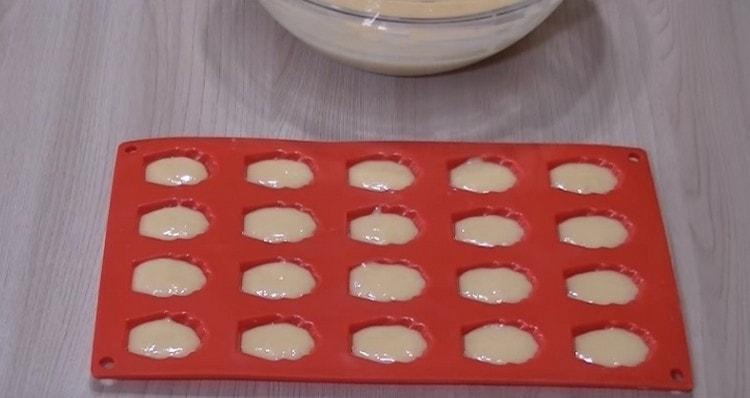 Разпределяме тестото в специални форми за маделини.