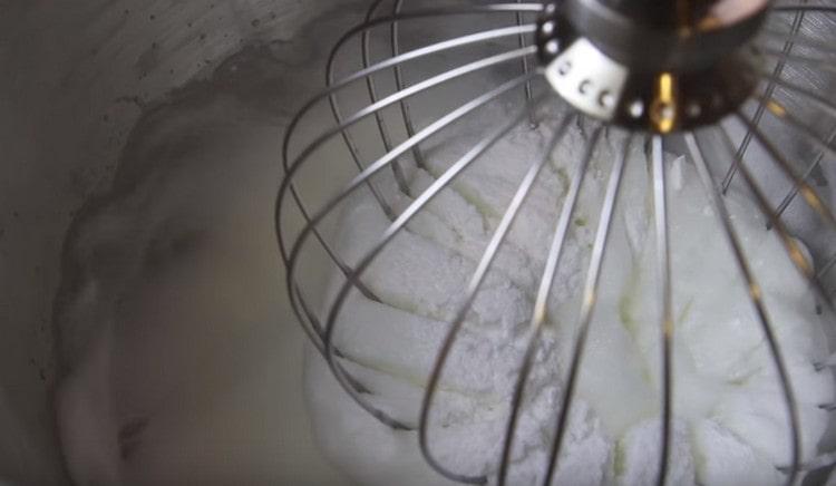 Adăugați zahărul pudră la proteine și continuați să bateți până la vârfurile persistente.