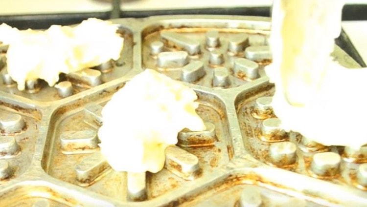 Do každé buňky formuláře vložíme lžíci těsta, zavřeme a pečeme 2 minuty na každé straně.