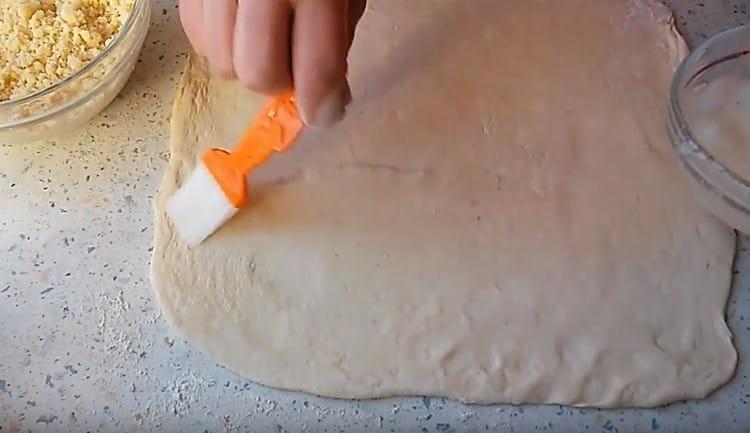 Изваждаме тестото от хладилника, разточваме и намазваме с протеин.