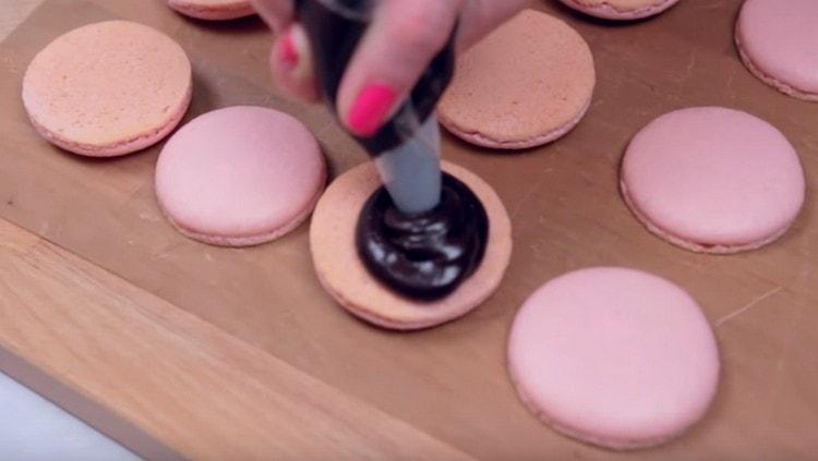 Strângeți crema pe o jumătate din macaroon.