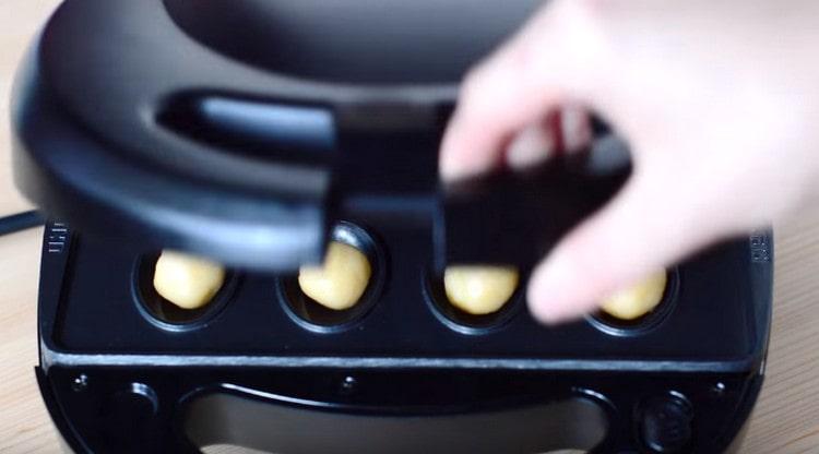 Coloque las bolas en un molde, cierre y hornee hasta que estén doradas.